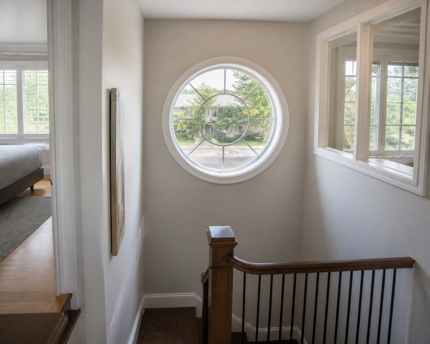 Interior stair landing with a circular window bringing in soft daylight