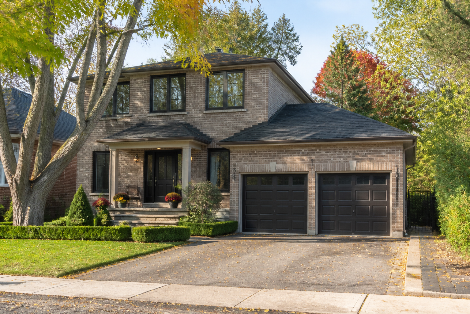 Well-kept Ontario detached house in early fall with updated vinyl windows and mature trees