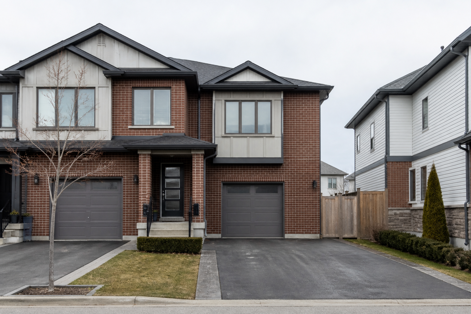 modern Canadian townhouse with large vinyl windows on an overcast day